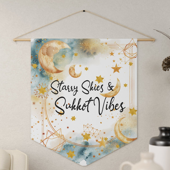 Decorative wall hanging with 'Starry Skies & Sukkot Vibes' text on a light background