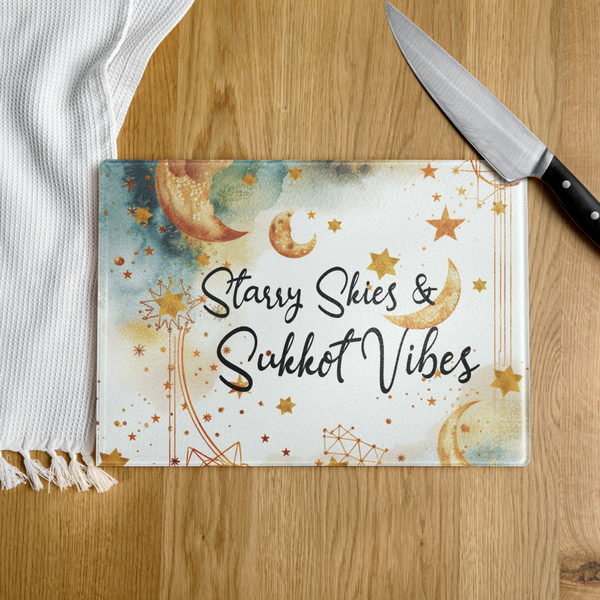 Cutting board with 'Starry Skies & Sukkot Vibes' design on a wooden surface with a knife.