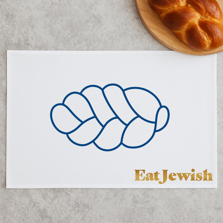 Oversized white kitchen towel printed with the Eat Jewish challah design, covering a mixing bowl of rising dough.